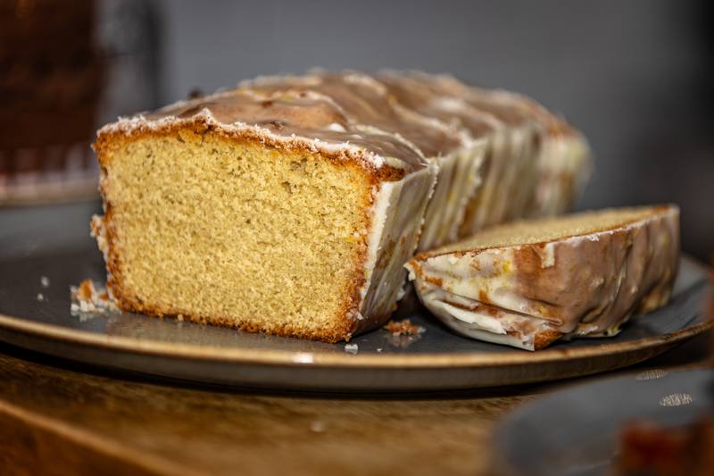 A sliced lemon drizzle loaf with a glossy glaze