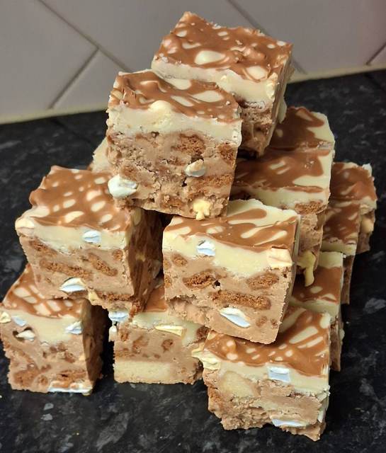 A stack of layered Biscoff and white chocolate squares with marshmallow pieces