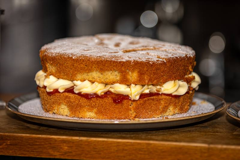 A Victoria sponge filled with jam and buttercream, dusted with sugar